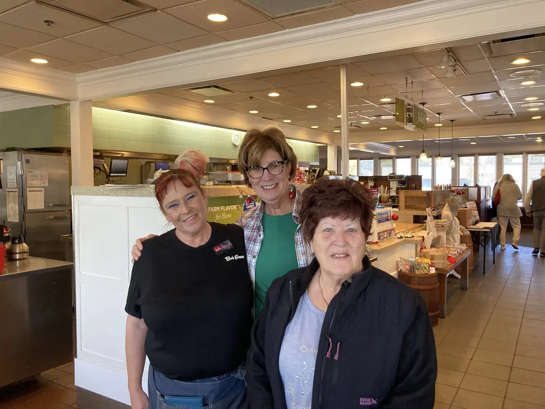 Three TPBG members smiling at a Monday meeting
