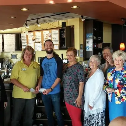 Members posing for a group picture in a restaurant